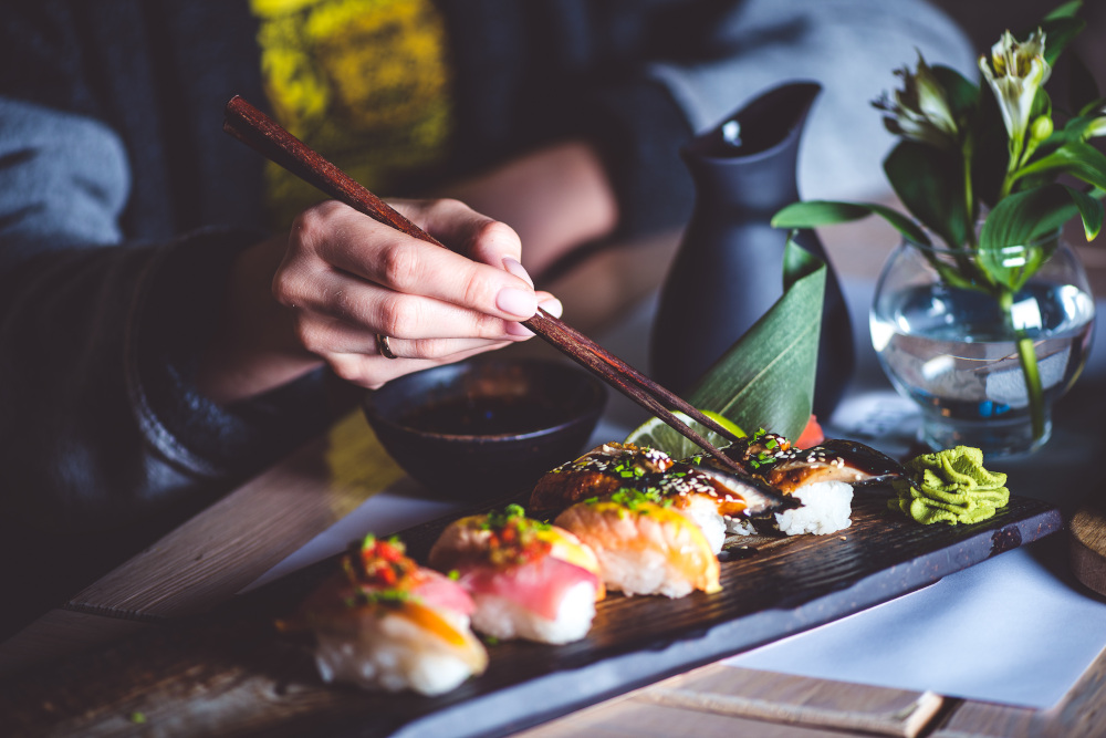 mężczyzna jedzący sushi pałeczkami