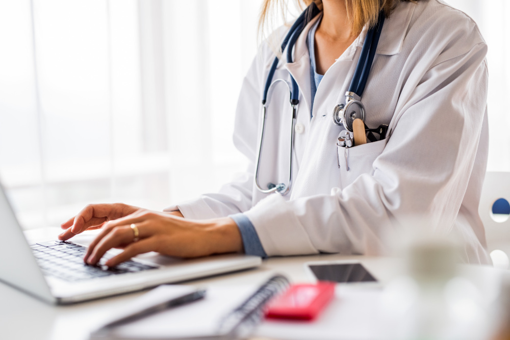 doktor wypisująca receptę na laptopie